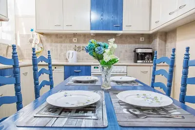 a blue table with plates and a vase of flowers at Sunny & Spacious 2BD apt near Acropolis in Athens
