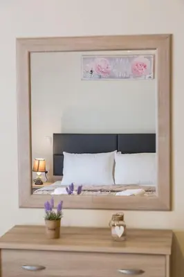 a bedroom with a large mirror above a bed at Sunny & Spacious 2BD apt near Acropolis in Athens