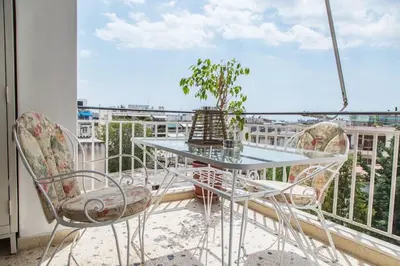 a table and chairs on a balcony with a window at Sunny & Spacious 2BD apt near Acropolis in Athens