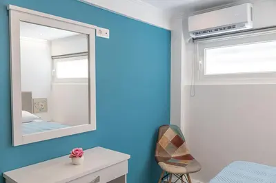 a blue room with a mirror and a chair at Debbie's cozy 2bdr - 2bth apt near Acropolis in Athens