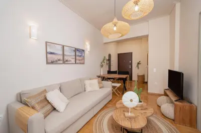 a living room with a couch and a tv at Meraki Koukaki by A&D Properties in Athens