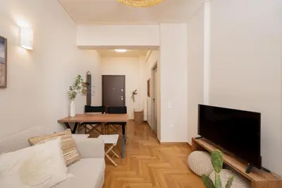 a living room with a couch and a flat screen tv at Meraki Koukaki by A&D Properties in Athens