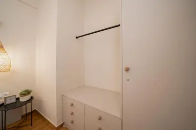 a bedroom with a white closet and a dresser at Meraki Koukaki by A&D Properties in Athens