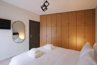 a bedroom with a white bed and a mirror at Tyto Alba Habitat in Athens