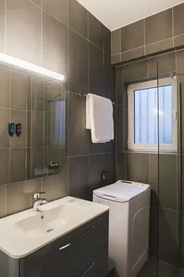 a bathroom with a toilet and a sink and a window at Tyto Alba Habitat in Athens
