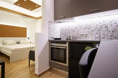 a kitchen with a stove and a bed in a room at Syntagma Hotel Style Luxury in Athens