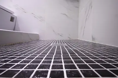 an empty bathroom with black tiled floor and white walls at Syntagma Hotel Style Luxury in Athens