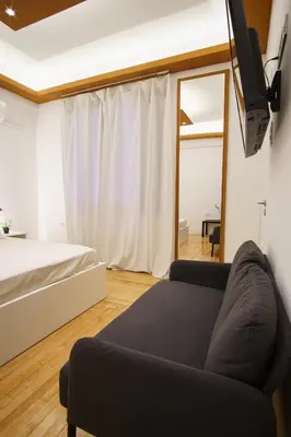 a living room with a couch and a tv at Syntagma Hotel Style Luxury in Athens