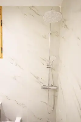 a shower in a bathroom with white marble walls at Syntagma Hotel Style Luxury in Athens
