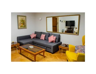 a living room with a blue couch and a mirror at Roza's apartment in Athens