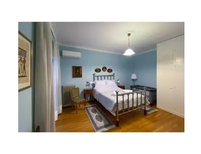a bedroom with a bed and a table with a chair at Roza's apartment in Athens