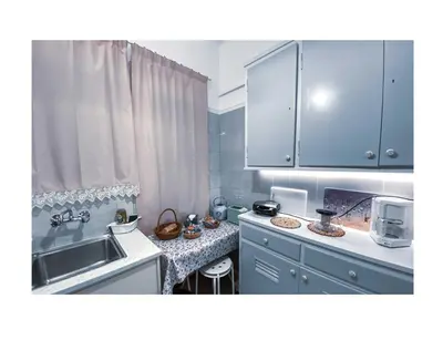 a kitchen with blue cabinets and a sink and a counter at Roza's apartment in Athens