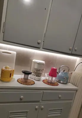 a shelf with various appliances on top of a dresser at Roza's apartment in Athens