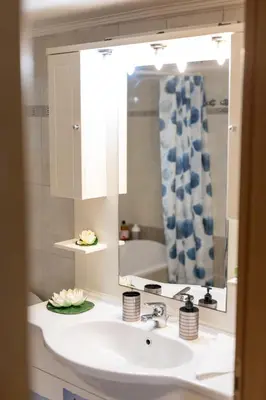 a bathroom with a sink and a mirror and a tub at Maria Cozy Getaway in Glyfada in Athens