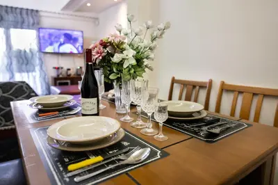 a table with plates and glasses and a bottle of wine at Maria Cozy Getaway in Glyfada in Athens