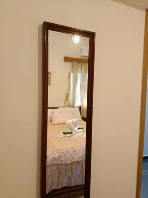 a mirror in a room with a bed in it at Maria Cozy Getaway in Glyfada in Athens