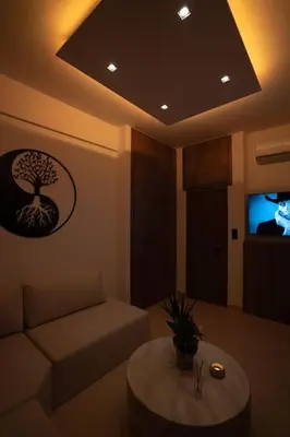 a living room with a couch and a table and a tv at V Suites - Apts & Spa in Athens