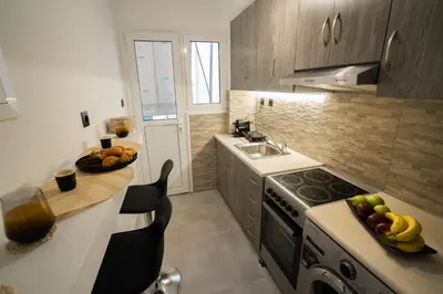 a kitchen with a sink and a counter with fruit on it at V Suites - Apts & Spa in Athens