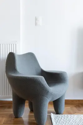 a gray chair sitting on the floor in a room at LIV - Elegant City Stay in Pagrati in Athens