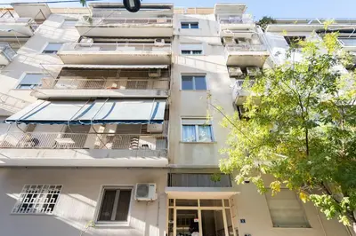 a tall apartment building with an awning in front of it at LIV - Elegant City Stay in Pagrati in Athens