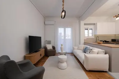 a living room with a couch and a tv at LIV - Elegant City Stay in Pagrati in Athens