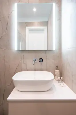 a white sink in a bathroom with a mirror at LIV - Captivating Apartment in Pagrati in Athens