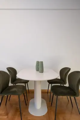 a white table with four chairs around it at LIV - Captivating Apartment in Pagrati in Athens