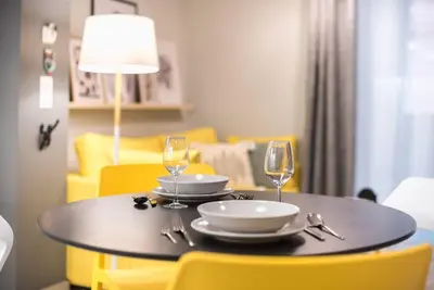 a dining room table with two wine glasses and yellow chairs at Affordable Luxury with parking 300Mbps wifi in Athens