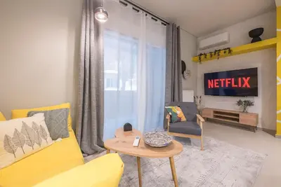 a living room with a yellow couch and a table at Affordable Luxury with parking 300Mbps wifi in Athens