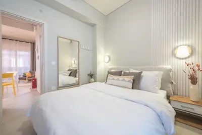 a white bedroom with a large bed and a dining room at Affordable Luxury with parking 300Mbps wifi in Athens