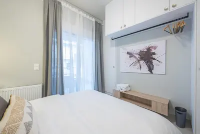 a bedroom with a white bed and a window at Affordable Luxury with parking 300Mbps wifi in Athens