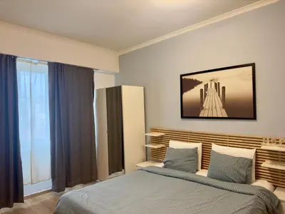 a bedroom with a bed and a large window at Sani Entire Flat near Syntagma Square in Athens