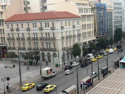 a busy city street filled with cars and buildings at Sani Entire Flat near Syntagma Square in Athens