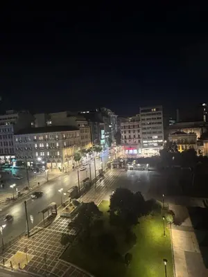 a city street at night with buildings and lights at Sani Entire Flat near Syntagma Square in Athens