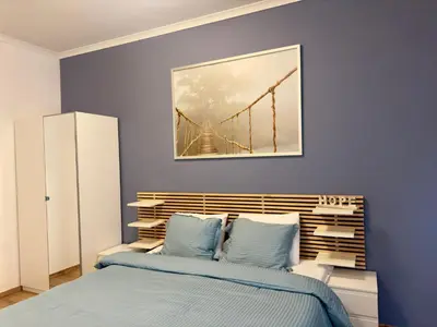 a bedroom with a bed and a painting of a bridge at Sani Entire Flat near Syntagma Square in Athens