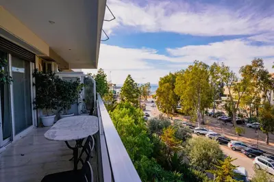 a balcony with a table and a view of a street at Glyfada central seaside apartment in Athens