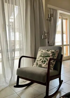 a chair sitting in a room with a window at Carones apartment in Athens