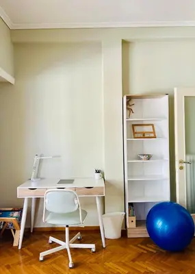 an office with a desk and a chair and a blue ball at Carones apartment in Athens