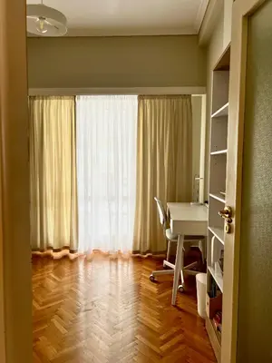 a room with a desk and a table and a window at Carones apartment in Athens