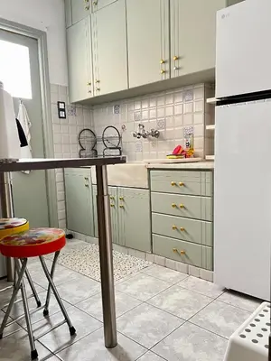 a kitchen with a table and a refrigerator at Carones apartment in Athens