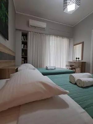 a bedroom with two beds with green sheets at Artemis ktparadise in Athens