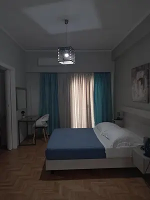 a bedroom with a bed and a chandelier at Artemis ktparadise in Athens