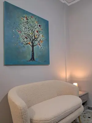 a chair in a room with a painting on the wall at Artemis ktparadise in Athens
