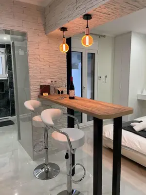 a kitchen with a table and stools with a bottle of wine at Romantic Jacuzzi&Spa Residence Near Acropolis- Fix Metro 180m in Athens