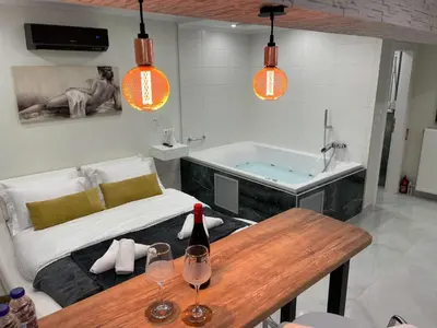 a bathroom with a tub and a table with wine glasses at Romantic Jacuzzi&Spa Residence Near Acropolis- Fix Metro 180m in Athens