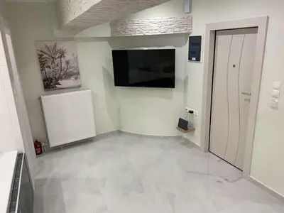 a living room with a television and a tiled floor at Romantic Jacuzzi&Spa Residence Near Acropolis- Fix Metro 180m in Athens