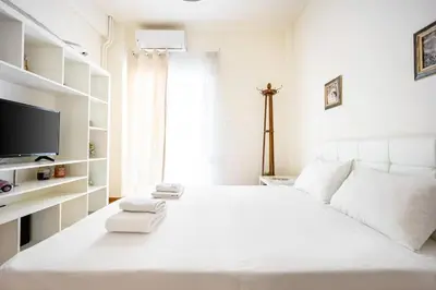 a white bedroom with a large white bed with towels on it at Acropolis 5 Hills 1st FLR Aprt by Lodgespot in Athens