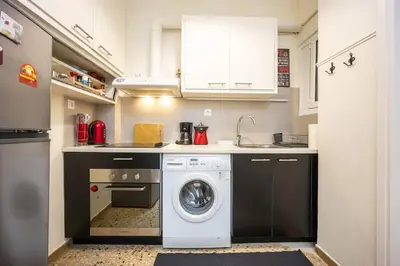 a kitchen with a washing machine and a washer at Acropolis 5 Hills 1st FLR Aprt by Lodgespot in Athens
