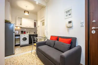 a living room with a couch and a kitchen at Acropolis 5 Hills 1st FLR Aprt by Lodgespot in Athens