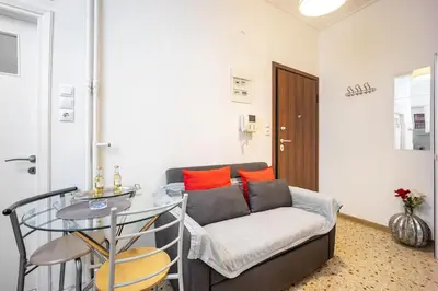 a living room with a couch and a glass table at Acropolis 5 Hills 1st FLR Aprt by Lodgespot in Athens